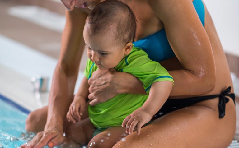 Mother with baby boy in the swimming pool on swimming class