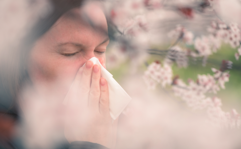 lady sneezing in a tissue due to hayfever