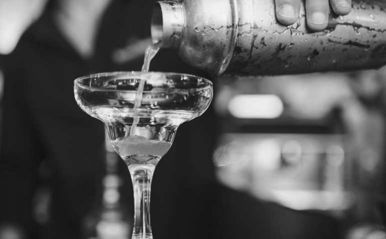 Bartneder pouring a drink in a glass