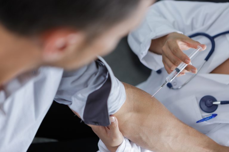 doctor injection flu vaccine to patients arm