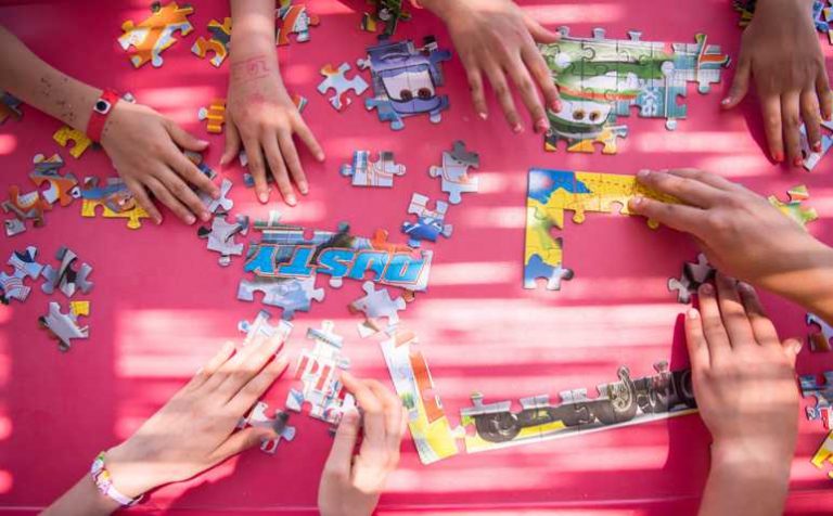 top view of kids hands playing with puzzles in outdoor playground